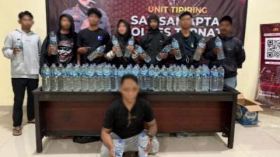 Polisi, barang bukti dan terduga pelaku (jongkok) diamankan karena membawa 80 botol miras tradisional (foto humas polres)