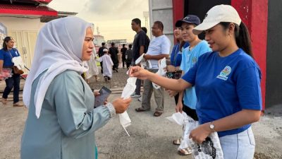 Pemuda Nasrani saat membagikan kantong plastik ke jamaah salat ied di gelora kiearaha