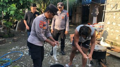 Personel Polsek Obi Selatan memusnahkan barang bukti minuman keras tradisional jenis cap tikus hasil razia di Desa Soligi (istimewa)