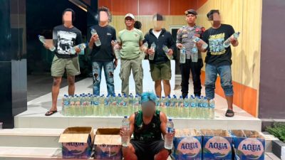 Personel Sat Samapta Polres Ternate menunjukkan barang bukti 210 botol minuman keras tradisional jenis cap tikus yang disita dalam razia di Kelurahan Kalumata (istimewa)